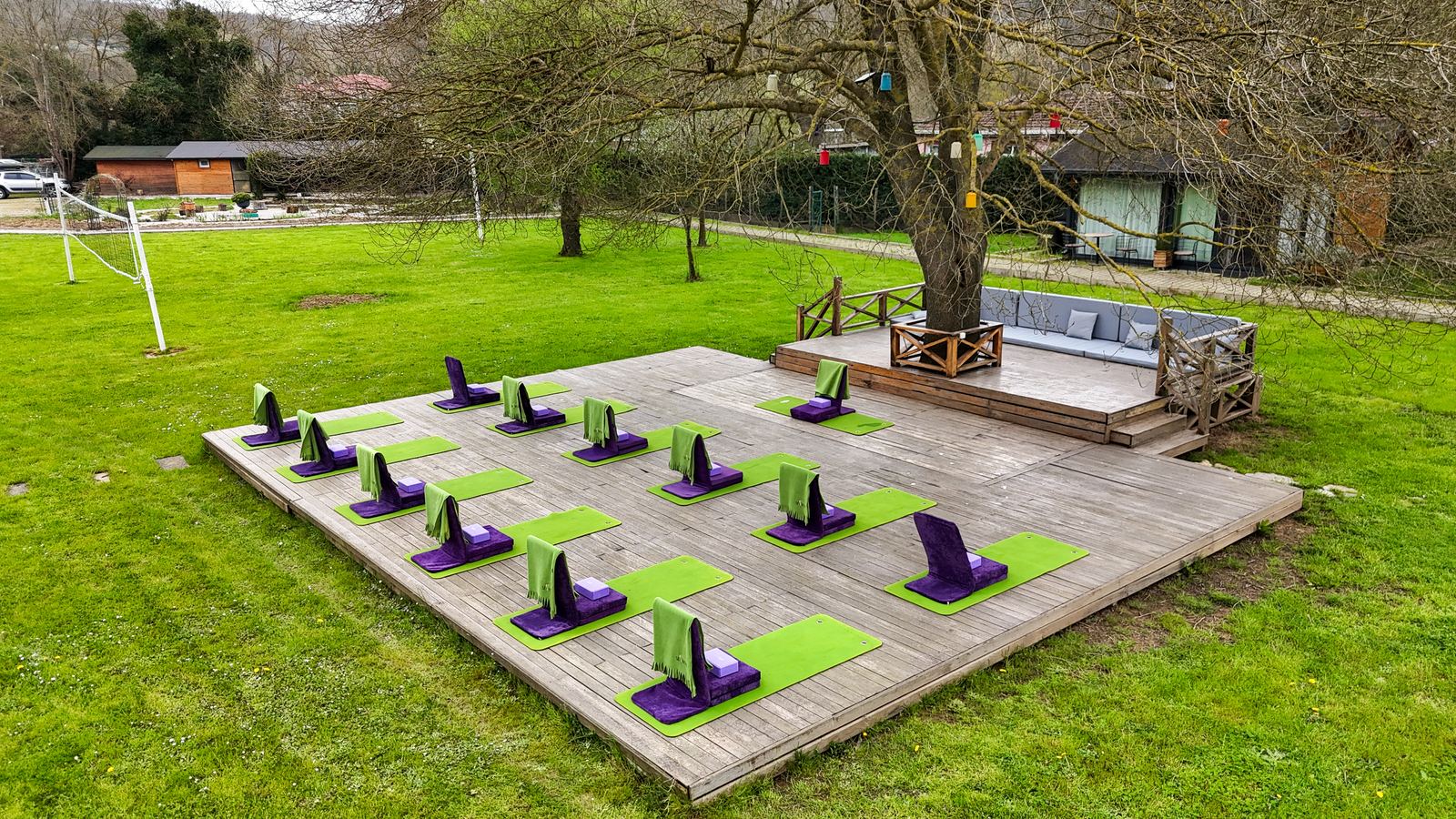 Bahçedeki ahşap platformda meditasyon minderleri, kuşbakışı